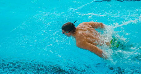 Professional Swimmer Performing Butterfly Stroke – Speed, Power and Determination. Swimming...
