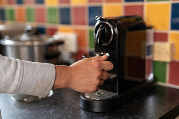 Brewing coffee with a machine in a colorful kitchen during morning hours