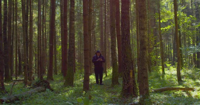 Modern lifestyle. A man backpacker traveling alone in forest wild. Man hiking trip through the green forest with backpack. Man traveler explore while walking in green forest. Travel concept