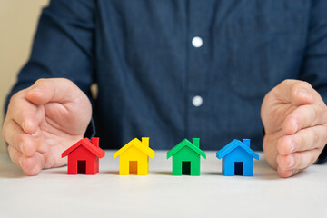 Insurance agent protects the houses with a gesture of protection. The concept of property insurance protection and housing. Security and safety in the home. Life insurance and family. Real estate