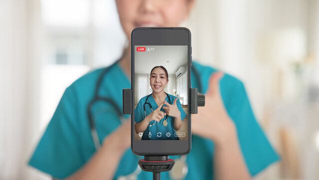 Young adult woman Gen Z asia people anti aging expert modern nurse live talk viral video selfie camera on mobile phone app mental health care. Online sharing digital virtual asian vlogger filming.