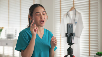 Young adult woman Gen Z asia people anti aging expert modern nurse live talk viral video selfie camera on mobile phone app mental health care. Online sharing digital virtual asian vlogger filming.