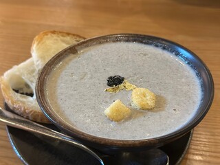 A meticulously presented bowl of rich, creamy Truffle Mushroom Soup, garnished with truffle bits and croutons, perfectly arranged with toasted bread, ready to be enjoyed.