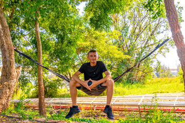 A man relaxes in a hammock in tropical jungle in Thailand.
