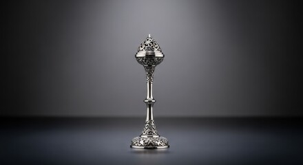 Elegant antique silver ornate chalice or censer with intricate floral carvings on a dark, reflective surface