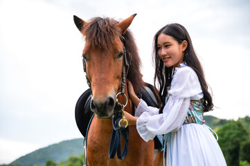Obraz premium Pretty girl in old fairy tale renaissance costume with white horse in nature