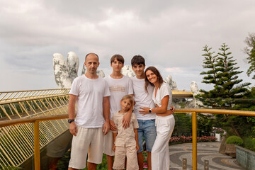Family with children, visiting the Golden bridge with big golden hands holding it in Da Nang, Ba Ha Hills travel destination, Vietnam
