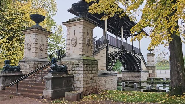 Historic Pont Napoleon bridge crossing the Moyenne - De&ucirc;le river with autumn trees in Lille, France