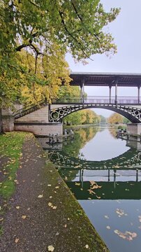 Historic Pont Napoleon bridge crossing the Moyenne - De&ucirc;le river with autumn trees in Lille, France
