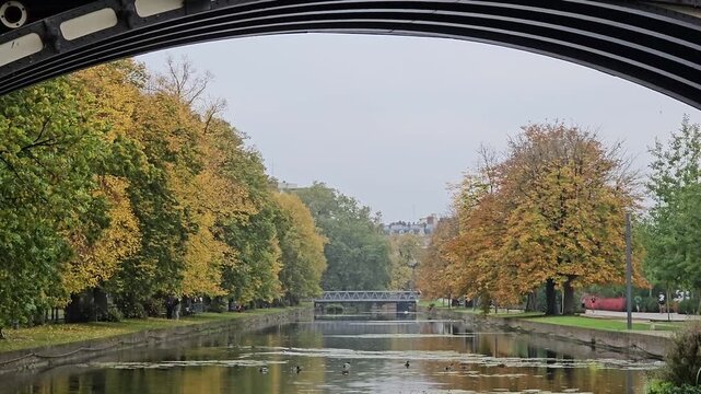 Historic Pont Napoleon bridge crossing the Moyenne - De&ucirc;le river with autumn trees in Lille, France