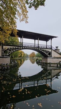 Historic Pont Napoleon bridge crossing the Moyenne - De&ucirc;le river with autumn trees in Lille, France