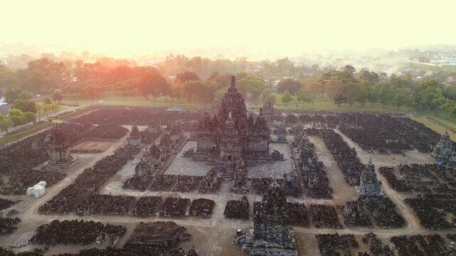 Aerial view of Prambanan Temple complex at sunrise in Yogyakarta, Indonesia. Ancient Hindu temple, UNESCO World Heritage Site, with morning mist. History, religion, spirituality, and travel themes.