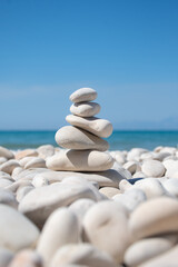 Stack of  white stones on a beach with sea and blue sky in the background. Zen and meditation background. Natural white stone beach. Tranquil scene