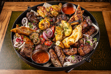 Assorted grilled meat and vegetables served with sauce.