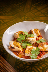 Bread pieces with tomato stew and herbs.