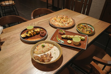 Assorted Indian and Continental Dishes Served on Wooden Table