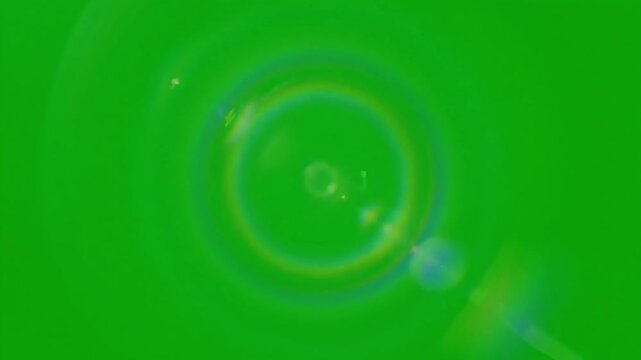 Vibrant green screen background with bright lens flare and colorful light reflections