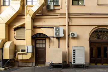 Air conditioners on the facade of yellow historical house. An air ventilation and cooling system and air purification technologies are installed. split system. cooling in hot weather. climate.