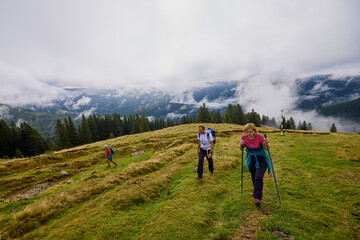 tourists on a mountain trail on a cloudy autumn day