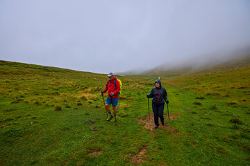 Fototapeta premium tourists on a mountain trail on a cloudy autumn day