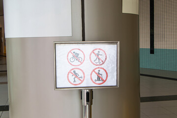 White signs icon symbol plate with man icon for No cycling, no skateboarding, no electric scooters. Warning of prohibited areas for playing with various devices. Regulations must be followed.