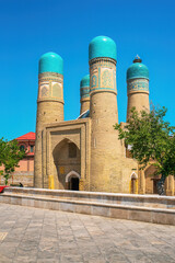 Obraz premium Chor Minor Madrasah or Madrasah of Khalif Niyaz-kul in Bukhara, Uzbekistan. Historic Islamic architecture with four turquoise domes under summer sun
