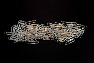 Cluster of Silver Paper Clips on Black Background