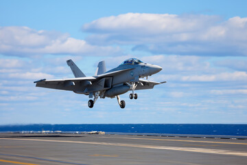 Fighter jet takes off from aircraft carrier under blue sky