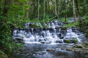 Samlan Waterfall, tier 3, tropical waterfall cascading through lush jungle in Thailand's natural forest reserve.