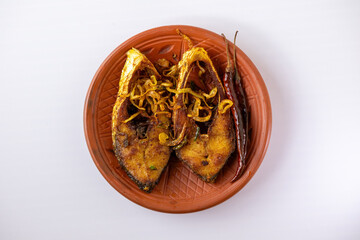 Delicious Hilsa fish fry (Ilish bhaja) with fried red chilies on a rustic clay plate, showcasing a traditional and popular Bengali meal. Top view