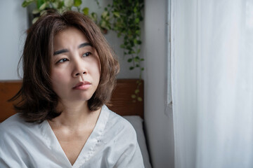 unhappy Asian woman looking sad, bored, and empty with lack of interest, feeling hopeless and dead...