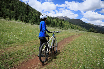 Fototapeta premium Riding mountain bike on grassland forest mountains
