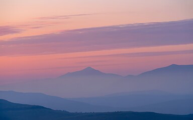 Misty mountain range at sunrise sky