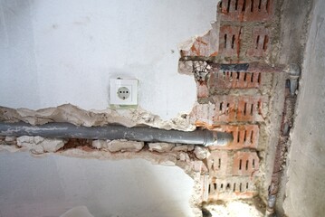 The plumbing work is currently in progress, showcasing exposed pipes and a bare floor in a bathroom renovation project