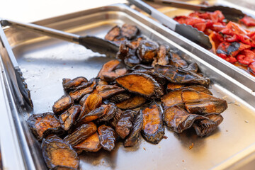 Baked eggplants on a tray at a barbecue buffet.