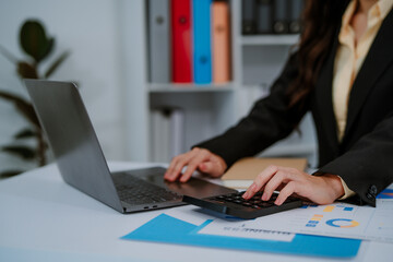 Focused businesswoman working at a desk with desktop computer in a bright office