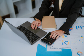 Focused businesswoman working at a desk with desktop computer in a bright office