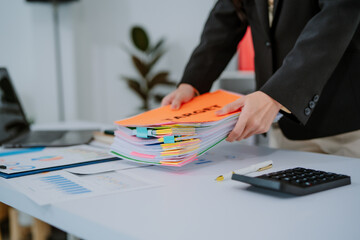 Young asian businesswoman smiling and working on digital tablet at office desk