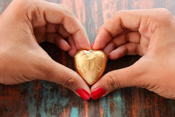 Gold plated chocolate heart shaped. Chocolate candy in the shape of heart covered in golden wrap....