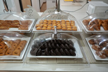 Assorted pastries and donuts displayed in hotel buffet in Benidorm, Spain.