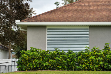 Boarded up windows with steel storm shutters for hurricane protection of residential house....