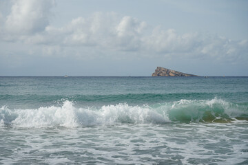 Beautiful summer beach waves with island view in Benidorm, Spain along the Mediterranean Sea