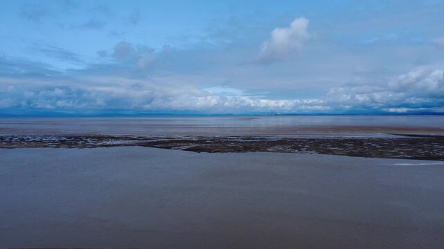 aerial view of the beach and sea in Fleetwood Lancashire at low tide with the large expanse of sand looking across Morecambe Bay to the village of Heysham and the Nuclear power station in the distance