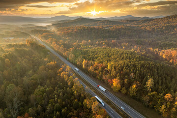 USA highway transportation infrastructure in North Carolina Appalachian mountains. American freeway road with fast driving semi trucks