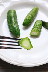 Pickled cucumbers on white ceramic plate.