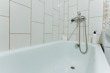 In the bathroom, there is a bathtub that features a shower head perfectly attached to it for enhanced convenience and usability, making it a versatile and practical plumbing fixture