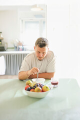 Man Enjoying Organic Cereal in a Bright Kitchen.