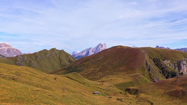 Veduta aerea mozzafiato delle Dolomiti con valli verdi, sentieri alpini e imponenti montagne rocciose sotto un cielo limpido. Un paesaggio naturale spettacolare che rappresenta la bellezza delle Alpi