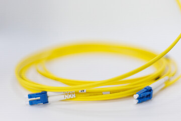 Yellow coiled fiber optic patch cord with blue connectors SFP modules are essential for high-speed data transmission over fiber optic networks.