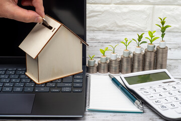 貯金箱と電卓と積みあがったコインで家の購入資金のイメージ